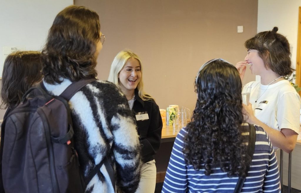 Group of new entrants chatting to Jodi Webster who works in Art Dept at the New Entrants' Base Drop-in Networking session