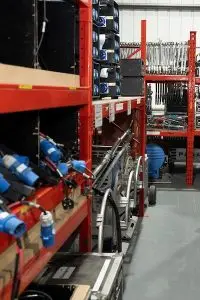 Electrical cables, distribution boxes, and flight cases on shelving