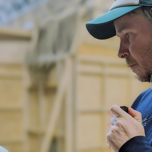 Mark O'Connor - Assistant Director, wears a covert radio ear piece.