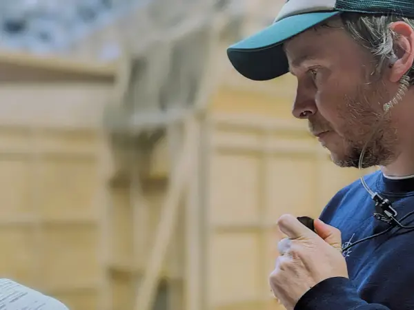 Mark O'Connor - Assistant Director, wears a covert radio ear piece.